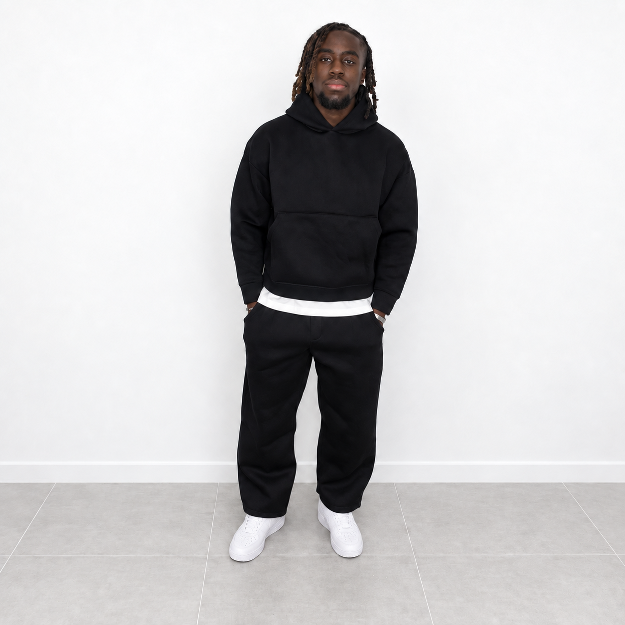 Ensemble de jogging noir pour homme, composé d'un pantalon et d'un sweat à capuche.