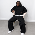 Ensemble de jogging noir pour homme, composé d'un pantalon et d'un sweat à capuche.